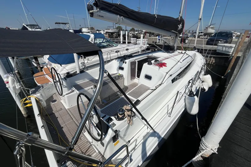  Yacht Photos Pics 2024 Jeanneau 380 sailboat docked at marina, featuring dual steering wheels and sleek design.