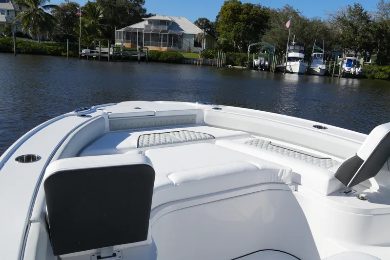 Your Next Boat! Yacht Photos Pics 2026 Blackfin 242 HB boat with white seating, docked near waterfront homes.