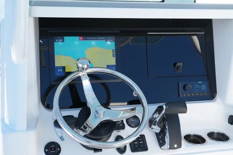 Your Next Boat! Yacht Photos Pics 2026 Blackfin 242 HB boat dashboard with steering wheel and navigation display.