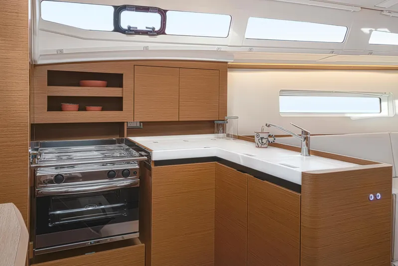  Yacht Photos Pics Modern kitchen interior of 2024 Jeanneau 380 yacht with sleek cabinetry and stainless steel appliances.