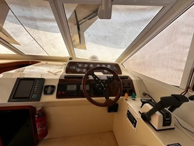  Yacht Photos Pics Interior helm of 1997 Fairline Phantom 37 yacht with steering wheel and control panel.