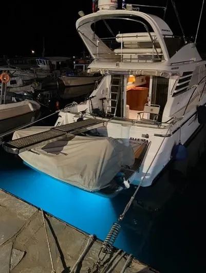  Yacht Photos Pics 1997 Fairline Phantom 37 yacht docked at night with illuminated blue water.