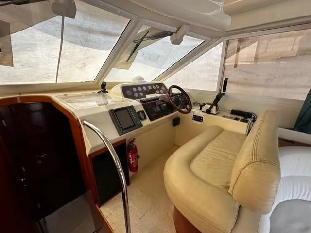  Yacht Photos Pics Interior of 1997 Fairline Phantom 37 yacht with beige seating and control panel.
