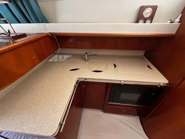  Yacht Photos Pics 1997 Fairline Phantom 37 yacht kitchen with wood cabinetry, sink, and built-in microwave.