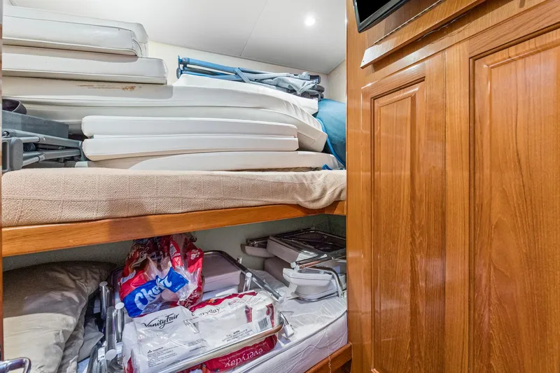  Yacht Photos Pics Storage area in 1998 Viking 72 Enclosed Bridge yacht with stacked supplies and wooden cabinetry.