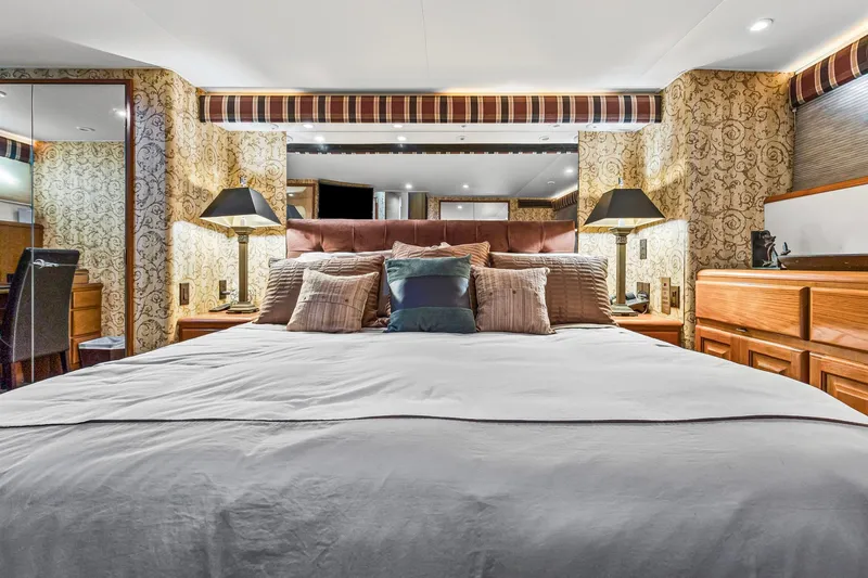  Yacht Photos Pics Luxurious bedroom interior on 1998 Viking 72 Enclosed Bridge yacht, featuring elegant decor and plush bedding.