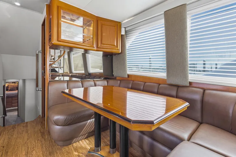  Yacht Photos Pics Luxurious interior of 1998 Viking 72 Enclosed Bridge yacht with leather seating and wooden table.