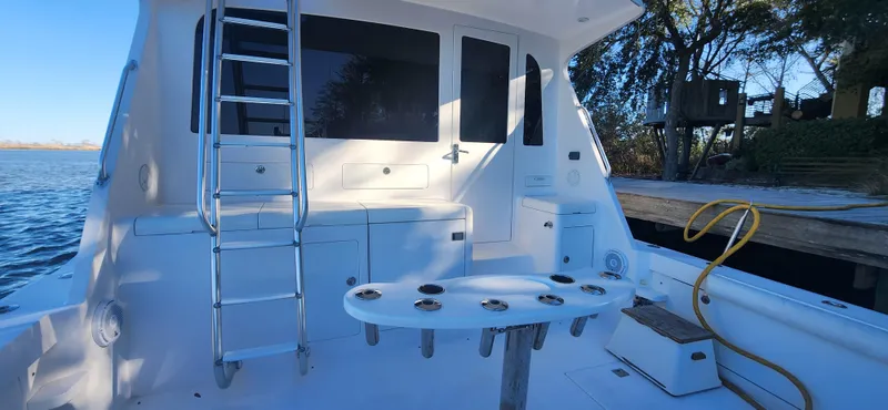 Laura K Yacht Photos Pics 2004 Cabo 48 Convertible yacht deck with ladder and fishing rod holders.