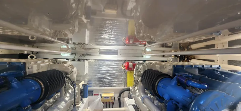 Laura K Yacht Photos Pics Engine room of a 2004 Cabo 48 Convertible yacht, featuring dual engines and mechanical components.