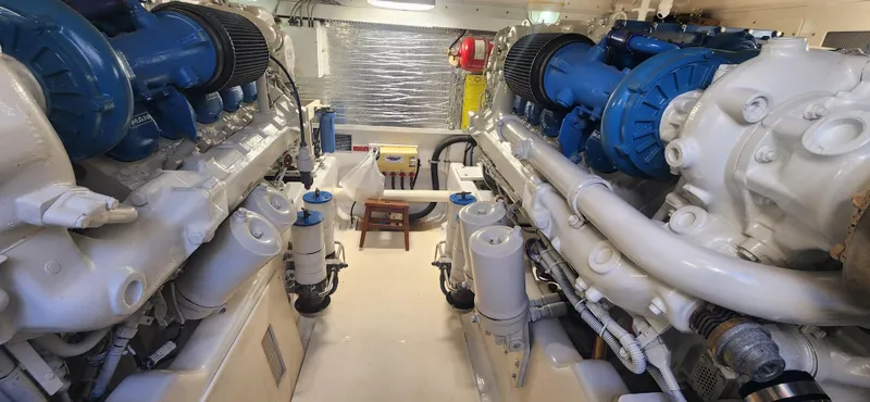 Laura K Yacht Photos Pics Engine room of a 2004 Cabo 48 Convertible yacht, featuring dual engines and mechanical components.