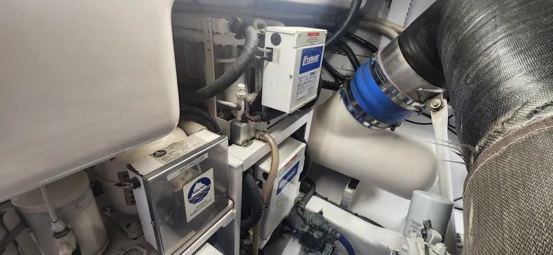 Laura K Yacht Photos Pics Engine room of a 2004 Cabo 48 Convertible yacht, showcasing mechanical components.