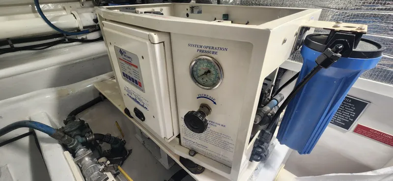 Laura K Yacht Photos Pics Engine room of 2004 Cabo 48 Convertible with water filtration system and pressure gauge.