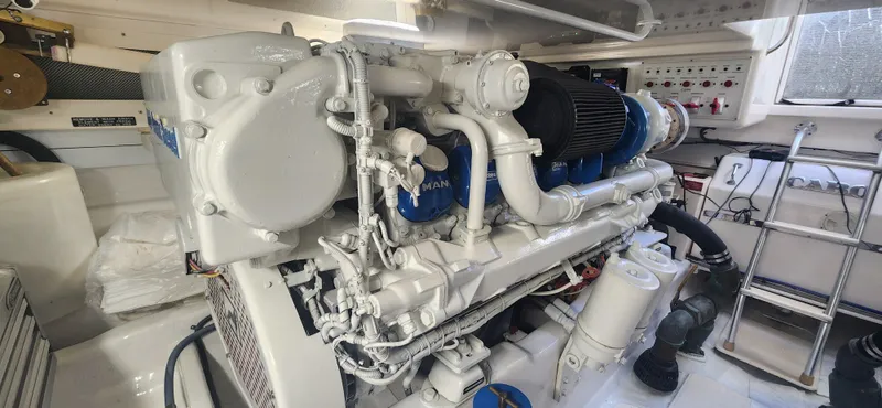 Laura K Yacht Photos Pics Engine room of a 2004 Cabo 48 Convertible yacht, showcasing a clean, well-maintained engine.