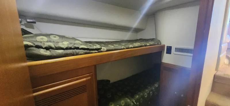 Laura K Yacht Photos Pics 2004 Cabo 48 Convertible yacht interior with cozy bunk beds and wooden cabinetry.