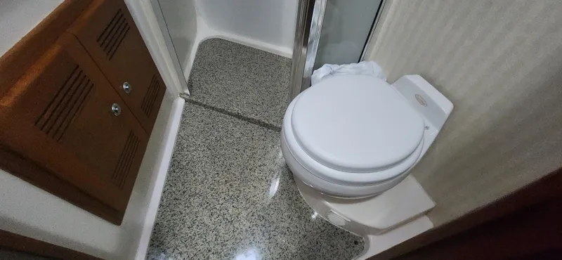 Laura K Yacht Photos Pics Bathroom interior of 2004 Cabo 48 Convertible yacht, featuring a toilet and shower area.