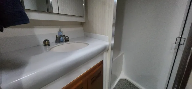 Laura K Yacht Photos Pics 2004 Cabo 48 Convertible bathroom with sink, mirror, and shower area.