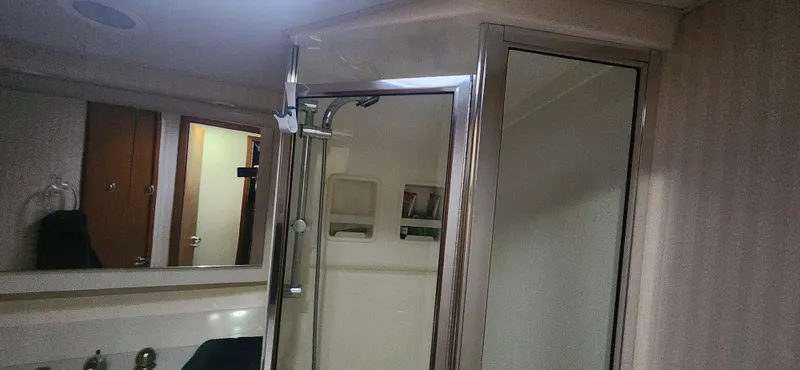Laura K Yacht Photos Pics Bathroom interior of 2004 Cabo 48 Convertible yacht with shower and mirror.