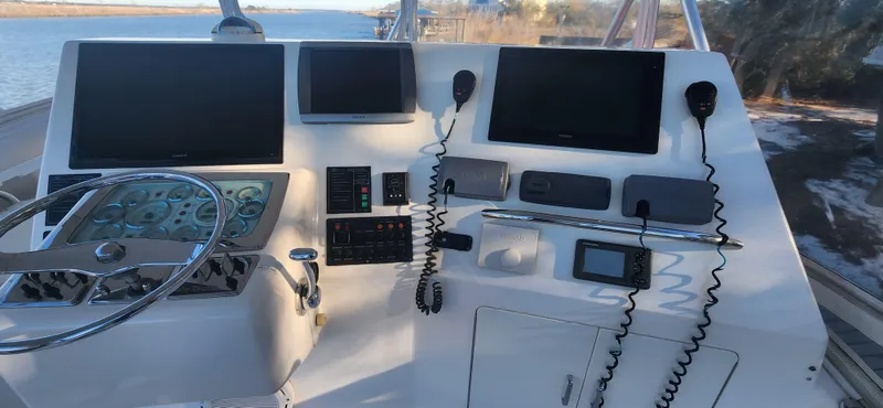 Laura K Yacht Photos Pics Helm of 2004 Cabo 48 Convertible yacht with navigation screens and controls.