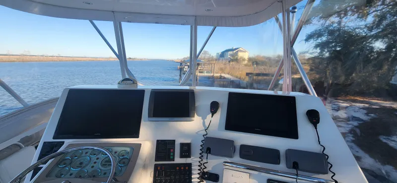 Laura K Yacht Photos Pics Helm of 2004 Cabo 48 Convertible yacht with navigation screens and river view.