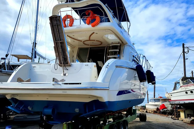  Yacht Photos Pics 2006 Cranchi Atlantique 48 yacht on dry dock, showcasing rear view and upper deck.