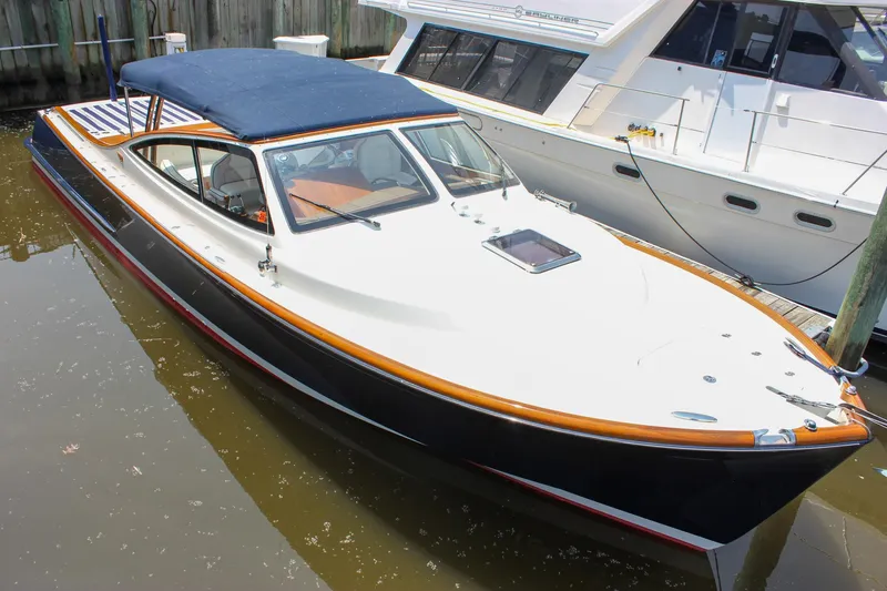 Sunny Daze Yacht Photos Pics 2008 Hinckley Talaria 38R Convertible docked, featuring sleek design and blue canopy.