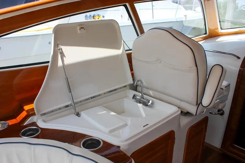 Sunny Daze Yacht Photos Pics 2008 Hinckley Talaria 38R Convertible interior with white seating and built-in sink.