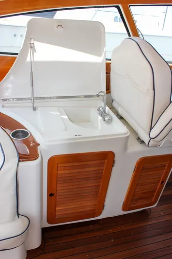 Sunny Daze Yacht Photos Pics 2008 Hinckley Talaria 38R Convertible yacht interior with sink and wooden cabinetry.