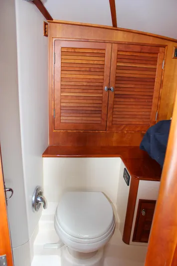 Sunny Daze Yacht Photos Pics 2008 Hinckley Talaria 38R Convertible yacht bathroom with wooden cabinets and white toilet.