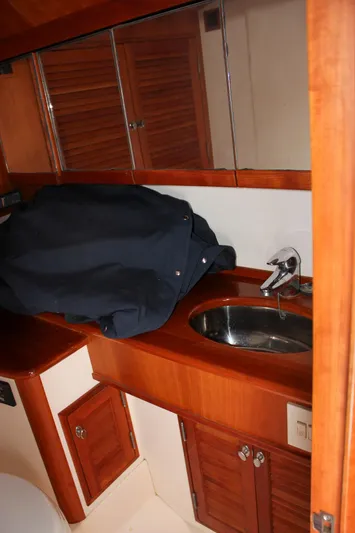 Sunny Daze Yacht Photos Pics 2008 Hinckley Talaria 38R Convertible bathroom with wooden cabinetry and stainless steel sink.