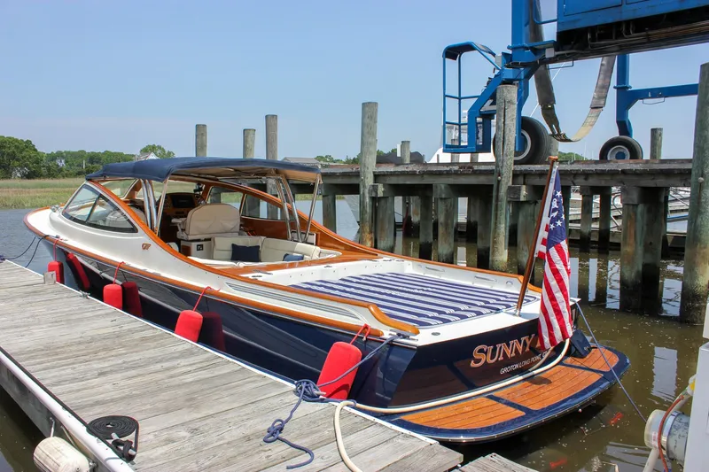 Sunny Daze Yacht Photos Pics 2008 Hinckley Talaria 38R Convertible docked with American flag and wooden deck.
