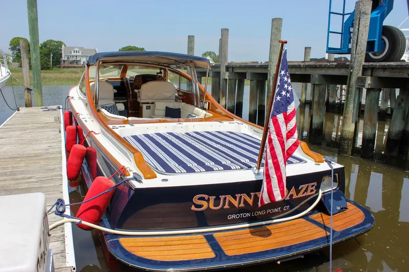 Sunny Daze Yacht Photos Pics 2008 Hinckley Talaria 38R Convertible docked, displaying American flag and striped seating.