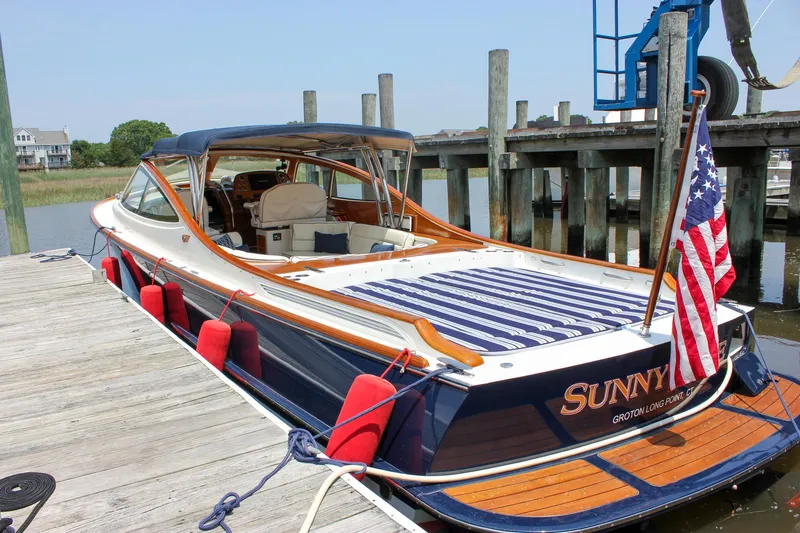 Sunny Daze Yacht Photos Pics 2008 Hinckley Talaria 38R Convertible docked, featuring elegant design and American flag.