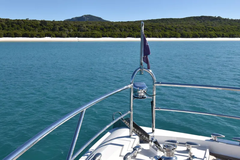 La Mar Yacht Photos Pics Bow of 2012 Lazzara LSX 78 yacht cruising near a scenic coastline.