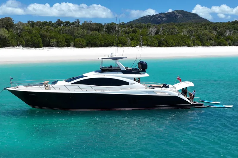 La Mar Yacht Photos Pics Luxurious 2012 Lazzara LSX 78 yacht anchored in turquoise waters near a sandy beach.