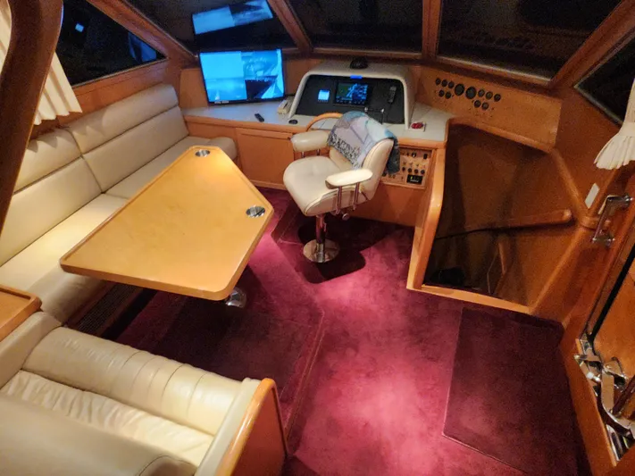  Yacht Photos Pics 1999 McKinna 57 Pilothouse interior with plush seating, control panel, and rich wood accents.