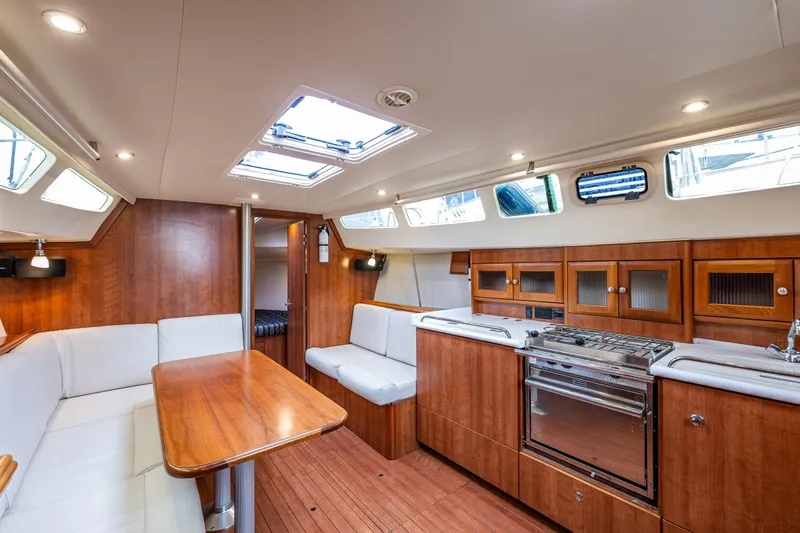  Yacht Photos Pics Interior of 2015 Marlow-Hunter 31 sailboat with wood finish, seating, and kitchen area.
