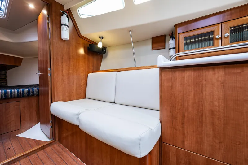  Yacht Photos Pics Interior of 2015 Marlow-Hunter 31 sailboat with wooden finish and white seating.