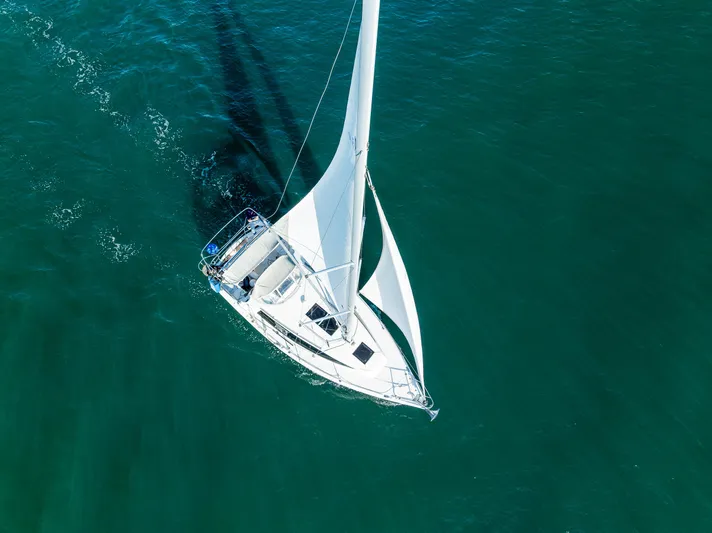  Yacht Photos Pics Aerial view of 2015 Marlow-Hunter 31 sailboat gliding on clear blue water.