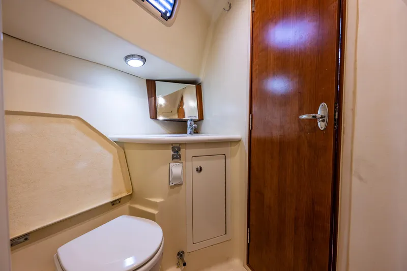  Yacht Photos Pics 2015 Marlow-Hunter 31 yacht bathroom with toilet, sink, mirror, and wooden door.