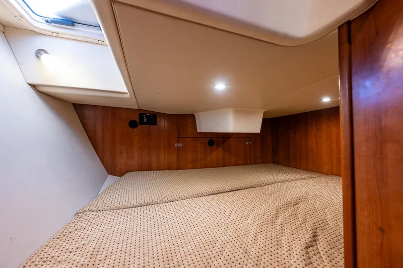  Yacht Photos Pics Interior cabin of 2015 Marlow-Hunter 31 sailboat, featuring cozy sleeping quarters and wooden paneling.
