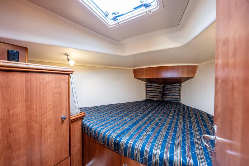  Yacht Photos Pics 2015 Marlow-Hunter 31 yacht cabin with striped bedding and wooden interior.
