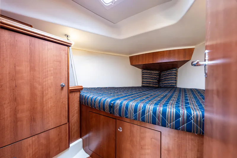  Yacht Photos Pics 2015 Marlow-Hunter 31 cabin interior with wood finish and striped bedding.