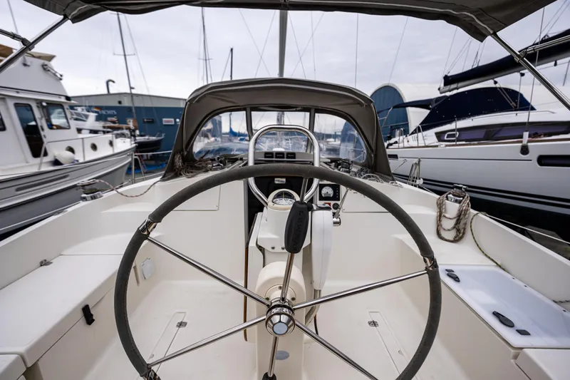  Yacht Photos Pics 2015 Marlow-Hunter 31 sailboat cockpit with steering wheel, docked among other boats.