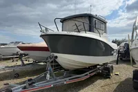 2019 Quicksilver 555 Pilothouse boat on trailer, parked outdoors under cloudy sky.
