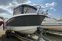 2019 Quicksilver 555 Pilothouse boat on trailer under cloudy sky.