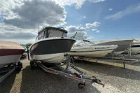 2019 Quicksilver 555 Pilothouse boat on trailer under a cloudy sky.