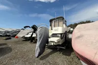2019 Quicksilver 555 Pilothouse boat in storage yard under blue sky.