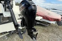 2019 Quicksilver 555 Pilothouse with Mercury outboard motor, parked on gravel.