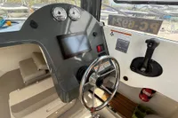 2019 Quicksilver 555 Pilothouse boat dashboard with steering wheel and control panel.