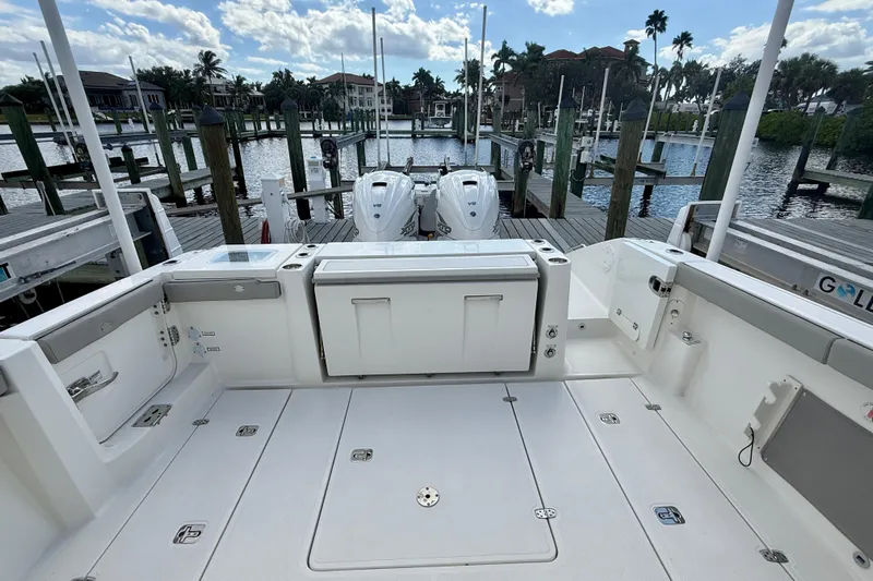  Yacht Photos Pics 2023 Pursuit S 358 Sport boat docked, featuring spacious deck and twin engines.